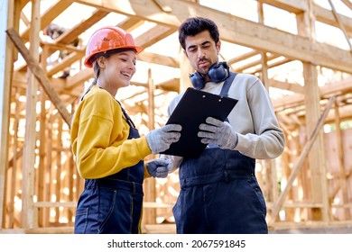 smiling architects constructors holding clipboard blueprints at construction site while discussing their work plan, have conversation, wearing working uniform and hardhat. architecture, building - Powered by Shutterstock