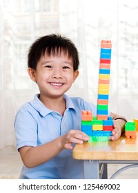 Smiling Asian Boy Playing With Building Blocks