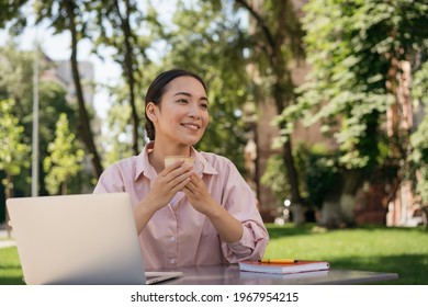 Smiling Asian Business Woman Drinking Coffee Looking Away Sitting In Cafe. Coffee Break Concept