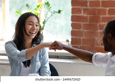 Smiling Asian businesswoman with African American colleague fists bump, employees or students greeting each other, celebrating good teamwork result, having fun together, friendship concept close up - Shutterstock ID 1449672410