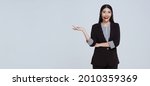 Smiling Asian businesswoman customer support phone operator isolated over gray background. call center and customer service concept.	
