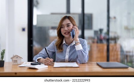 Smiling Asian Businesswoman, Lawyer, Real Estate Agent, Banker Or Consultant Making Cell Phone Call To Client At Office.