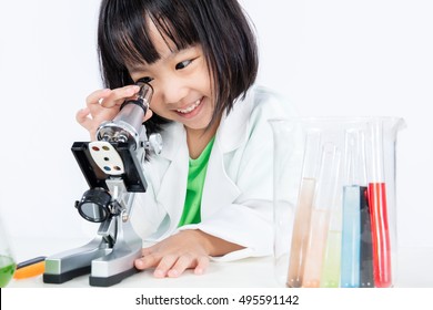 Smiling Asian Chinese Little Girl Working With Microscope in isolated white background.