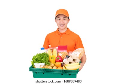 Smiling Asian Delivery Man In Orange Uniform Holding Grocery Basket Isolated On White Background