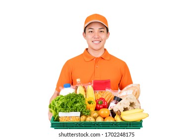 Smiling Asian Delivery Man In Orange Uniform Holding Grocery Basket Isolated On White Background