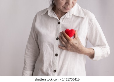 Smiling Asian Elderly Woman Holding Red Heart Shape, Concept Of Prevention Heart Disease Concept.