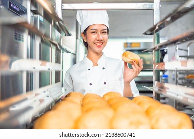 Smiling  asian  female bakers looking at camera.Chefs  baker in a chef dress and hat, cooking together in kitchen.Team of professional cooks in uniform preparing meals for a restaurant in   kitchen. - Powered by Shutterstock