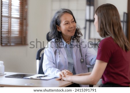 Smiling Asian female doctor having a positive interaction with a female patient.

