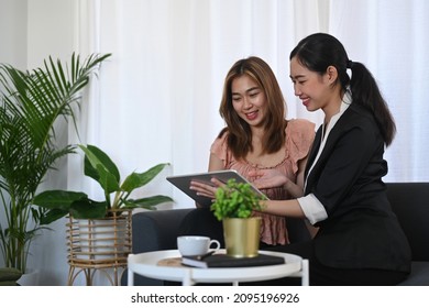 Smiling asian female insurance agent offering life insurance to woman customer. - Shutterstock ID 2095196926
