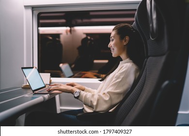Lächelnde asiatische Passagierin von Zug tippen auf Laptop-Computer arbeiten auf Geschäftsreise, Frau digitale Nomade zufrieden mit der Verbindung für Online-Jobsuche Informationen in sozialen Netzwerken
