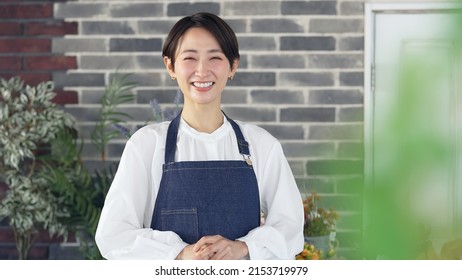 Smiling Asian Female Shop Clerk. Restaurant. Flower Shop.