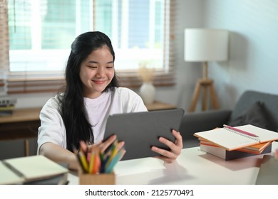 Smiling Asian Girl Learning Online In Virtual Classroom On Digital Tablet At Home.