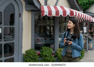 Smiling Asian Girl Tourist Looking At Entrance Door Of The Fairytale Like House On Street While Walking Around Carmel By The Sea With Camera During Her Stay In California Usa