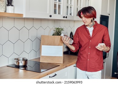 Smiling Asian Guy Checking Online Home Delivery Of Groceries, Holding Phone