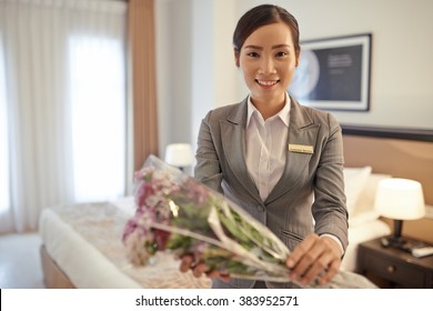 Smiling Asian Hotel Manager Giving Flowers To Customer