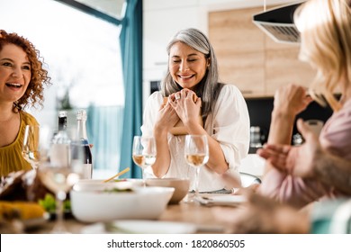 Smiling Asian lady rejoicing and closing his eyes while holding a box with a gift - Powered by Shutterstock