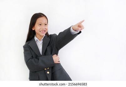 Smiling Asian little girl kid wear business suit and pointing up isolated on white background.