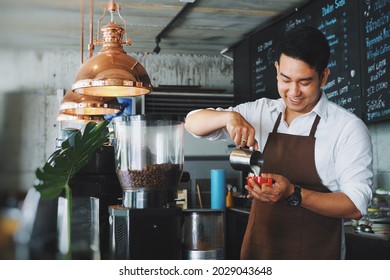 Smiling Asian man barista working at cafe. - Shutterstock ID 2029043648