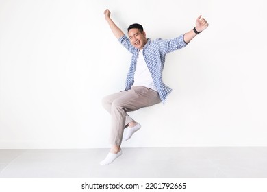 Smiling Asian man full length in casual shirt floating in the air with copy space. Asian man full length in standing shot on isolated.