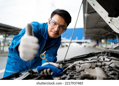 Smiling Asian Mechanic In Blue At Garage, Asian Mechanic Fixing Car In Garage, Car Safety Inspection, Engine In Garage, Repair Service Concept. Auto Mechanic.
