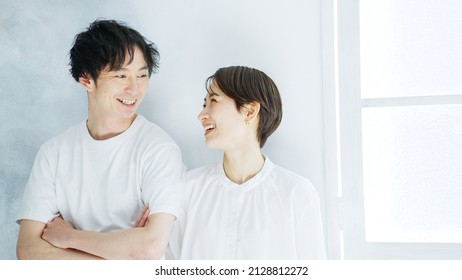 A smiling Asian middle-aged couple.