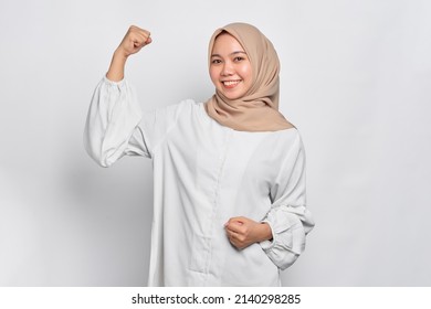 Smiling Asian Muslim Woman Raises Arms And Shows Muscle Isolated Over White Background