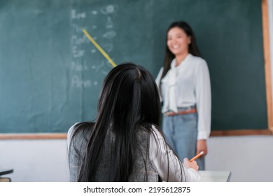 Smiling Asian Teacher Woman Teaching Student In English Classroom, Female Teacher Writing On Blackboard, High School And Back To School Concept.