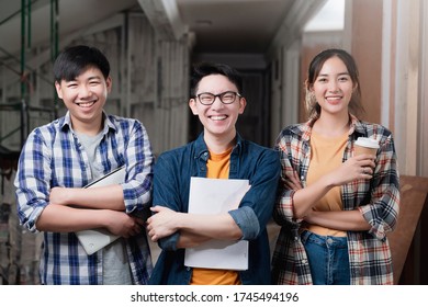 smiling asian teamwork of yound interior dreative designer portrait stand together hand chest confident and smart team with background of construction home renovate