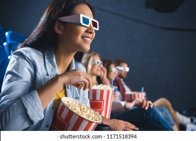 Smiling Asian Woman In 3d Glasses With Popcorn Watching Movie In Cinema