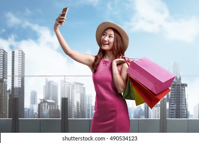 Smiling Asian Woman Shopping Outdoor Taking Selfie Or Self Portrait With Their Cell Phone