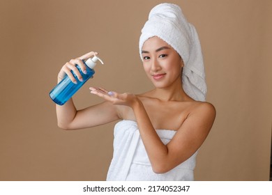 Smiling Asian Woman Using Moisturizing Lotion After Shower