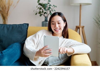 Smiling Asian woman using tablet - Powered by Shutterstock