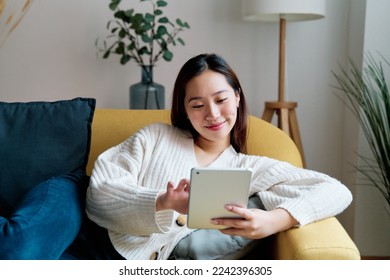 Smiling Asian woman using tablet - Powered by Shutterstock