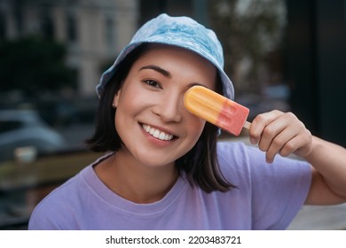 Smiling Asian Woman Wearing Stylish Panama Holding Ice Cream Near Face Looking At Camera	