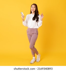 Smiling asian woman white shirt on yellow background use smartphone with happy feeling show appreciation - Shutterstock ID 2169340893