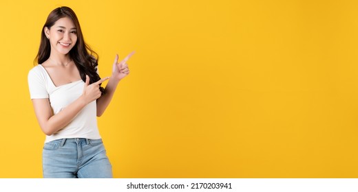 Smiling Asian Woman White Shirt On Yellow Background Pointing On Space Area