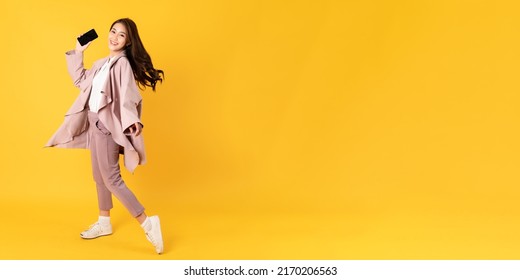 Smiling Asian Woman White Shirt And Blazer On Yellow Background Holding Smart Phone