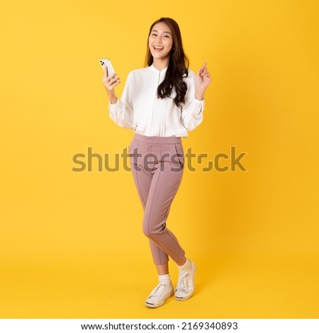 Smiling asian woman white shirt on yellow background use smartphone with happy feeling show appreciation