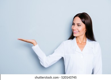 Smiling Assistant  Holding Something On Hand And Demonstrating It