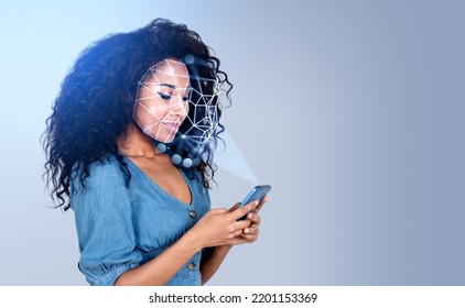 Smiling attractive African American businesswoman wearing formal wear is trying to unlock her smartphone. Concept of facial recognition, biometric scanning, artificial intelligence - Powered by Shutterstock