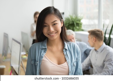 Smiling Attractive Asian Student Or Intern Looking At Camera, Happy Chinese Girl Office Employee Posing In Coworking, Cheerful Young Woman Professional Or Company Manager Head Shot Portrait