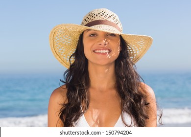 Smiling Attractive Dark Haired Woman Wearing Straw Hat Posing On The Beach 