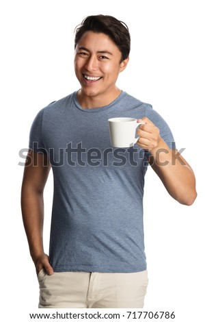 Smiling attractive man wearing a blue shirt and bright pants, holding a mug standing in front of a white background.