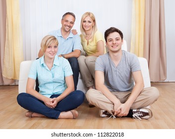 Smiling Attractive Young Family With A Teenage Son And Daughter Posing Together In Group Portrait