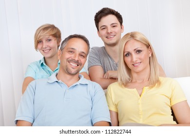 Smiling Attractive Young Family With A Teenage Son And Daughter Posing Together In Group Portrait