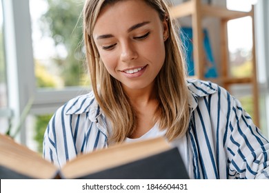 Smiling attractive young woman designer reading book while sitting at the workshop - Shutterstock ID 1846604431