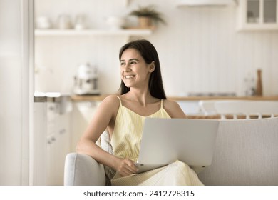 Smiling attractive young woman enjoy carefree leisure at home with laptop. Electronic commerce client, on-line work, study or amusement, remote communication, blogging, freelance job using internet