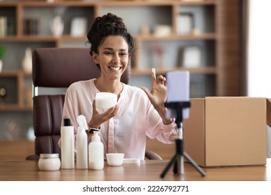 Smiling attractive young woman shooting video on smartphone, influencer blogger recording beauty vlog for social network, holding demonstrating cosmetic products, makeup haul, tutorial, home interior - Shutterstock ID 2226792771
