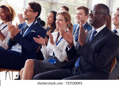 Smiling audience applauding at business seminar