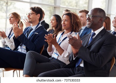Smiling audience applauding at a business seminar - Shutterstock ID 737530333